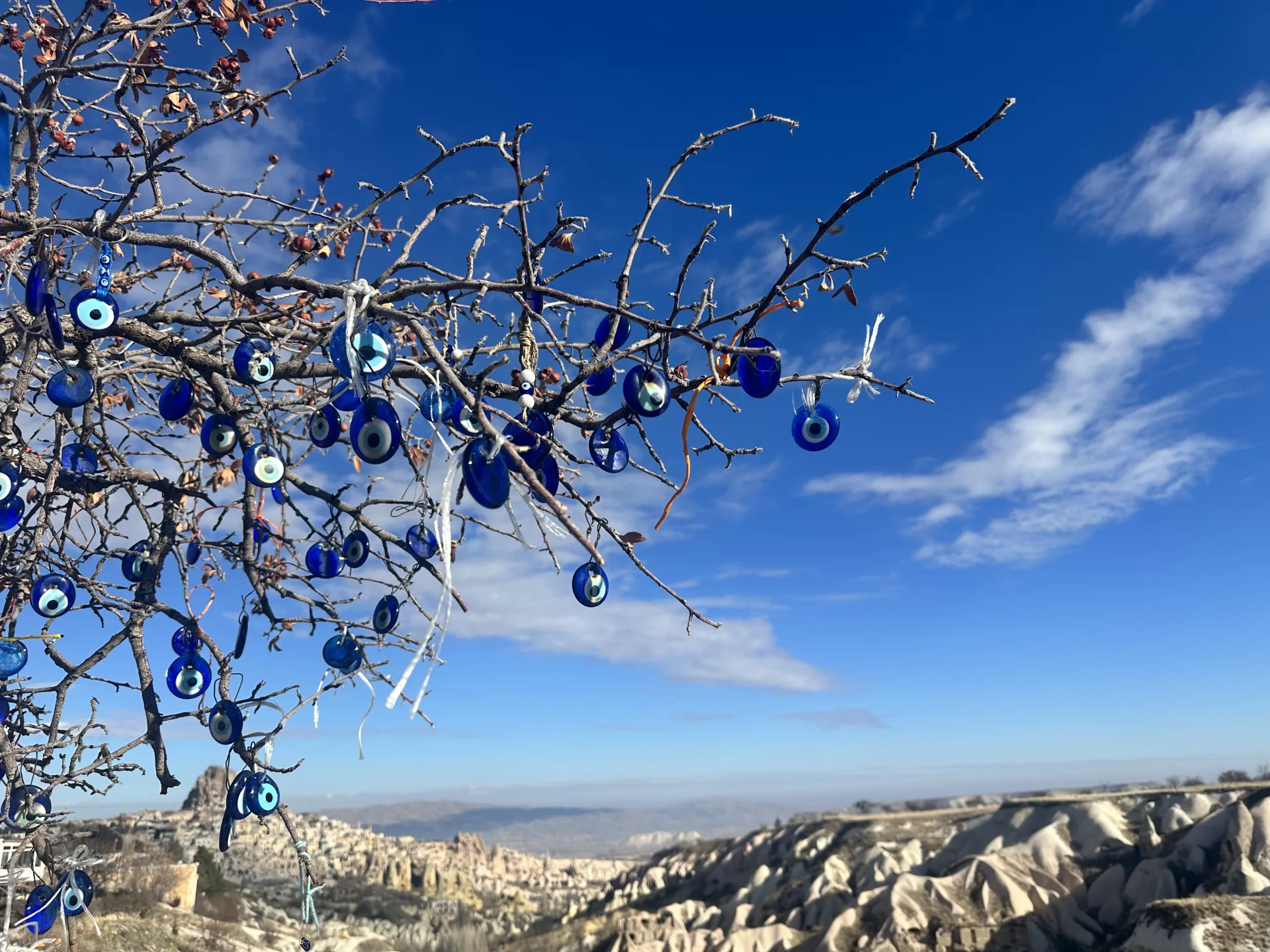 Blue evil-eye ornaments above a Cappadocia valley