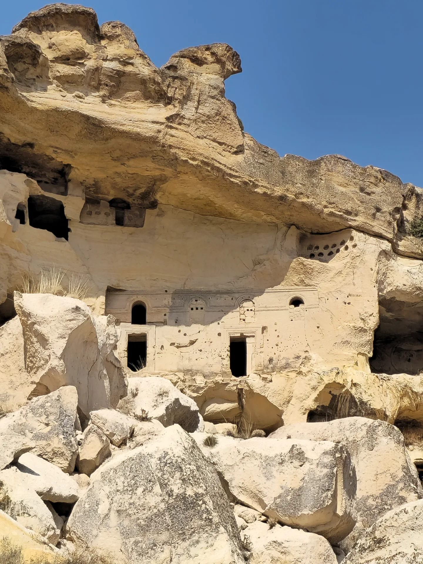 Sunlit rock-cut façade and doorways in Cappadocia