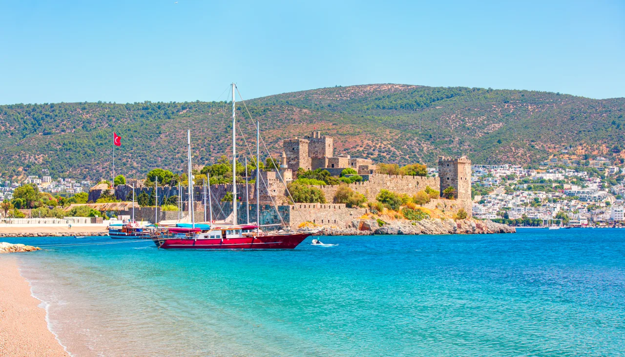 Bodrum Castle and a sailing boat beside the beach