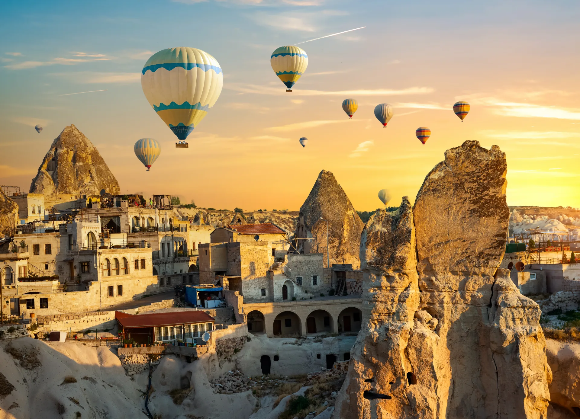 Globos sobre una población excavada en la roca de Capadocia al amanecer