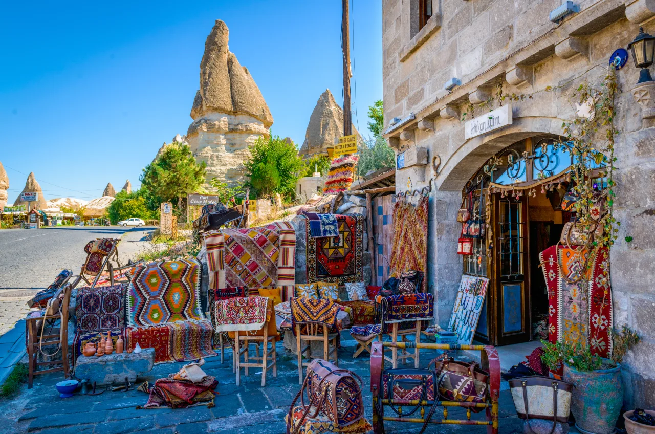 A Cappadocia street with carpet displays and rock formations