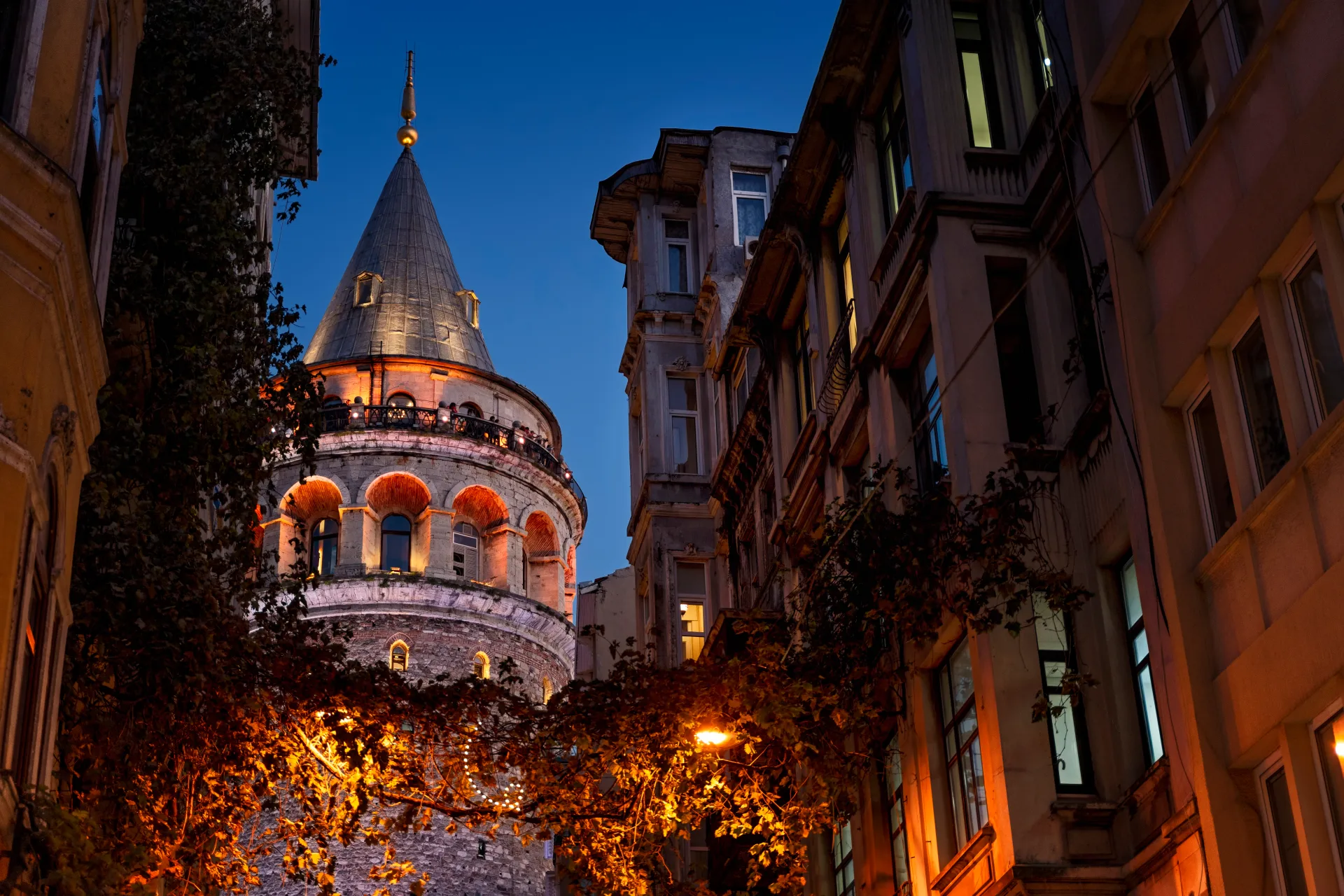 La Torre de Gálata iluminada al anochecer entre edificios de Estambul