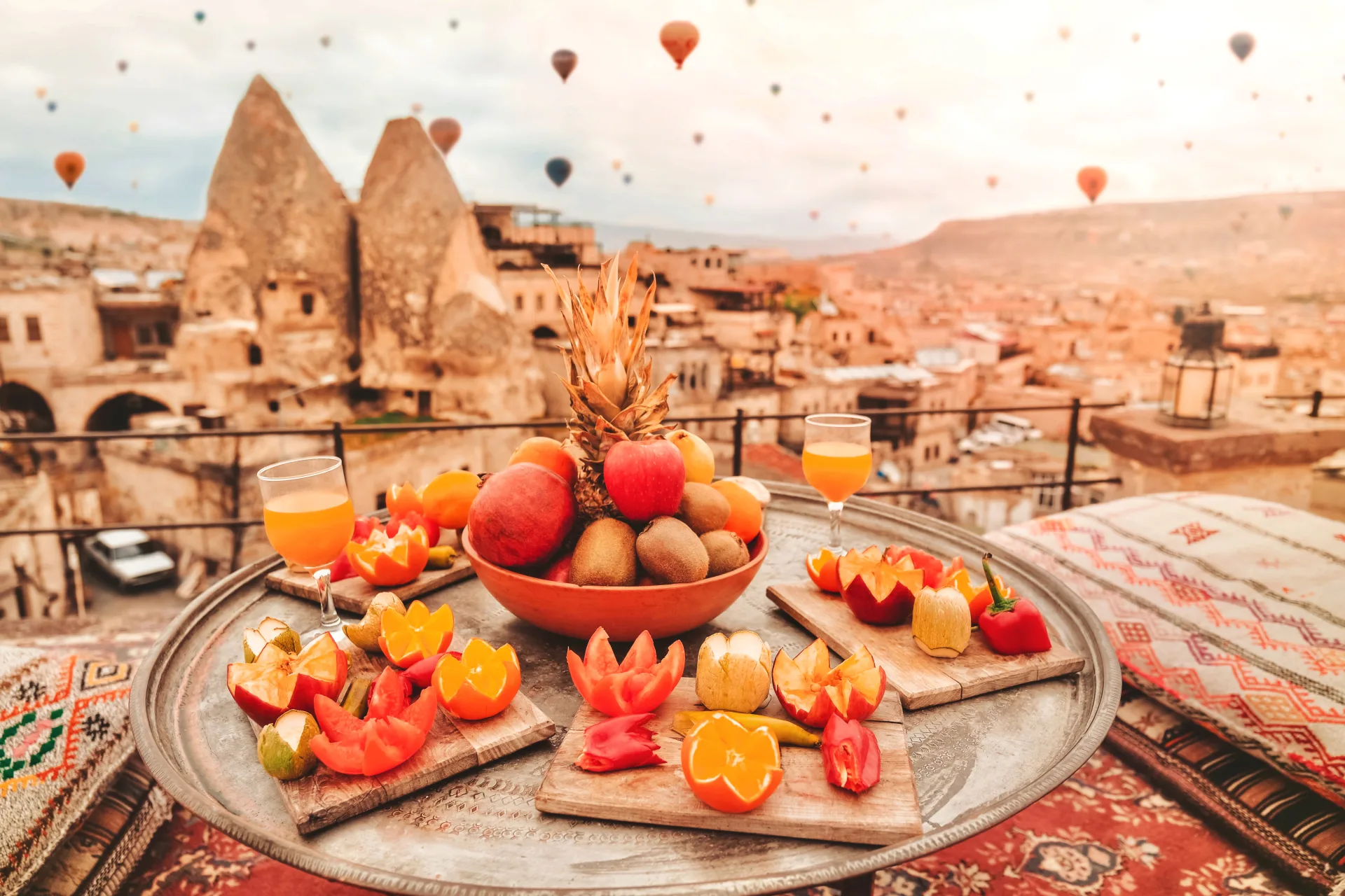 A breakfast display on a Cappadocia terrace with balloons beyond