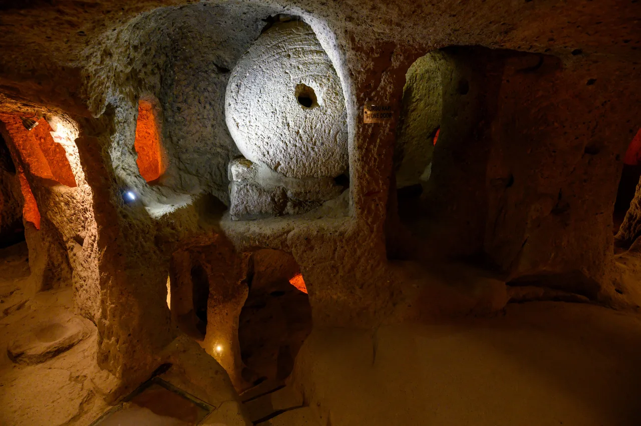 A stone doorway and wheel-shaped stone in Kaymaklı’s underground rooms