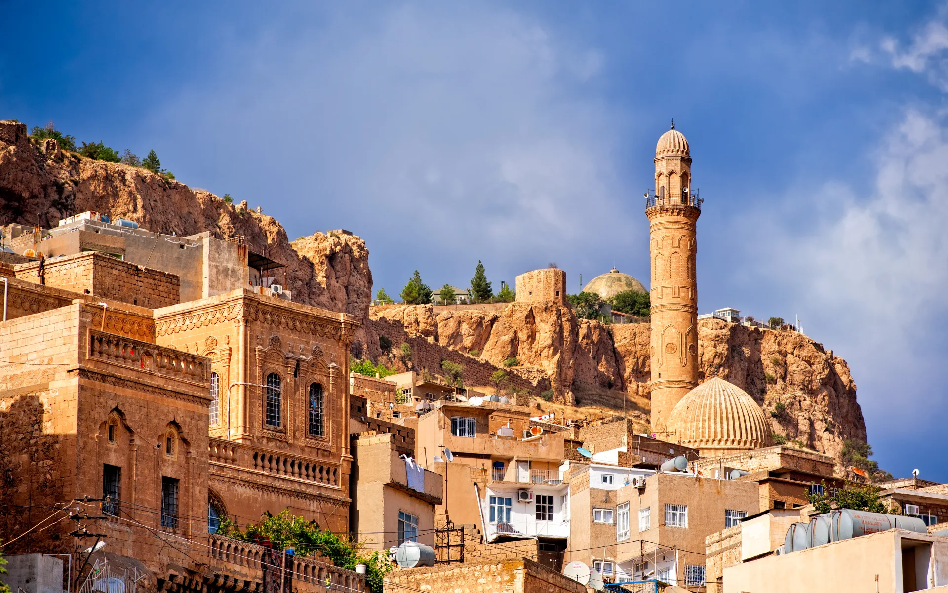 Edificios de piedra, un minarete y la ladera de Mardin