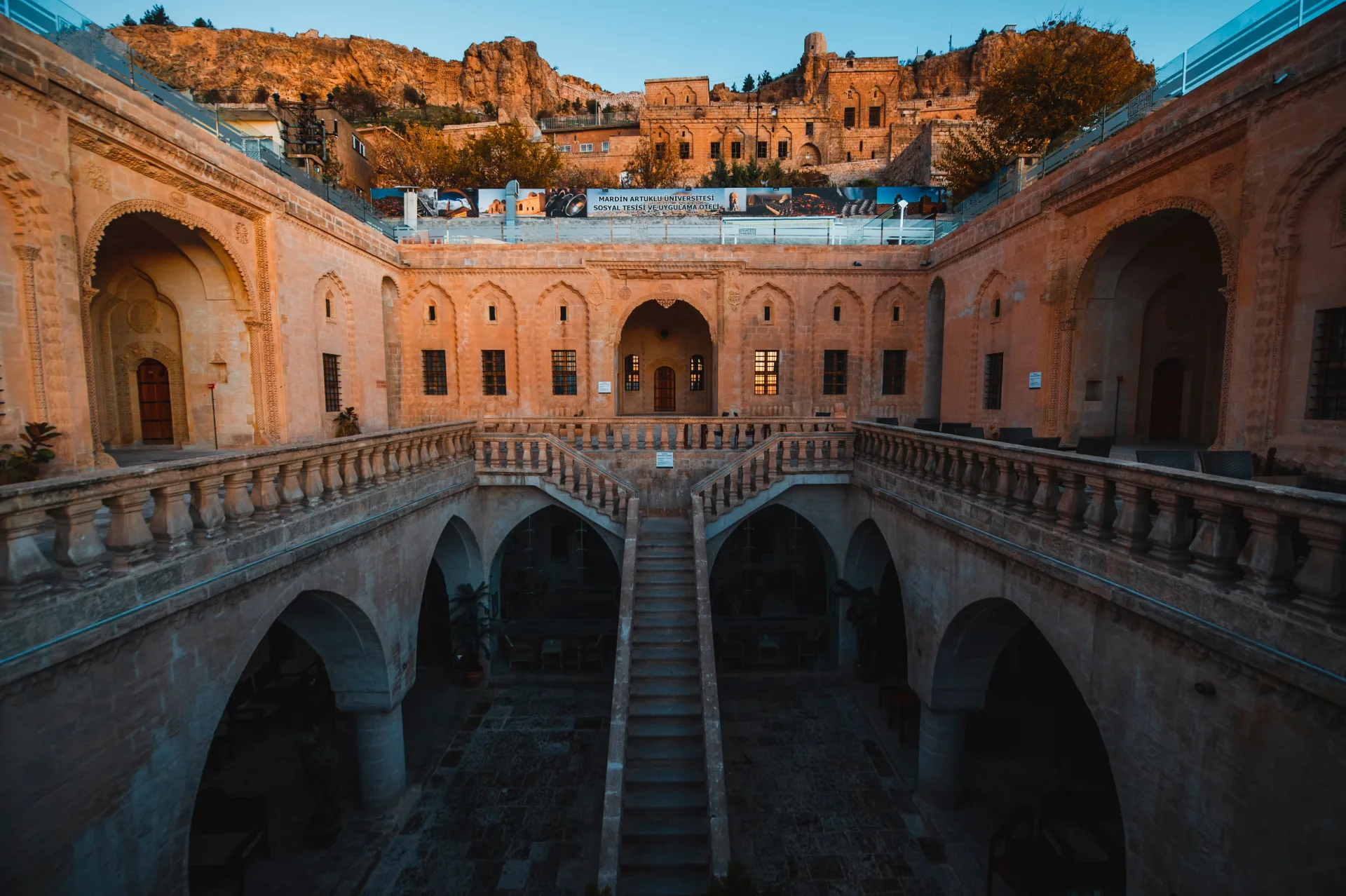 Arched stone galleries around a historic Mardin courtyard
