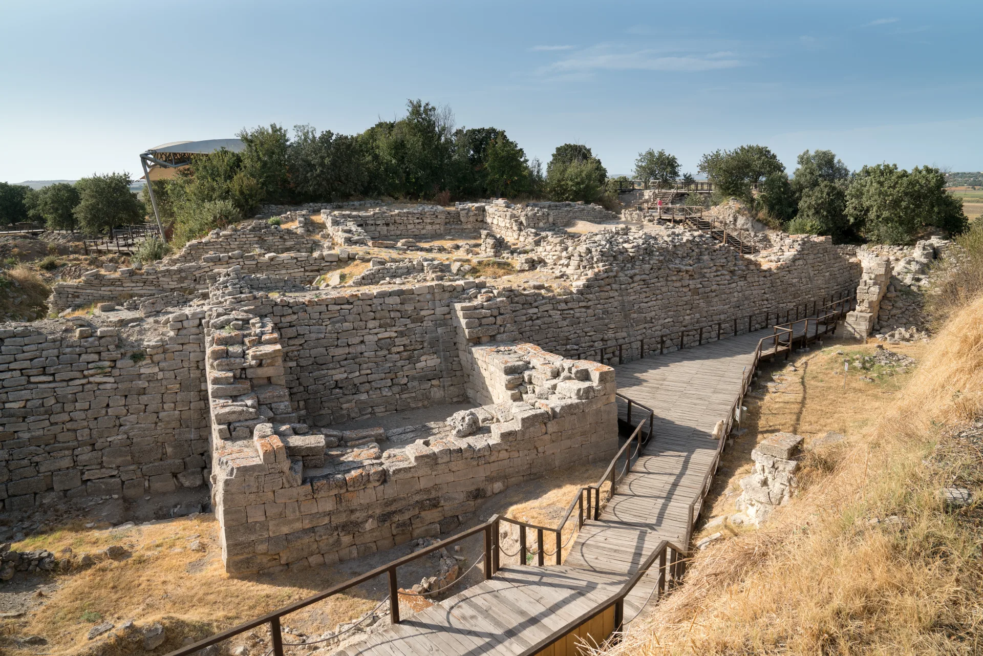 Excavated stone walls and a visitor path at Troy
